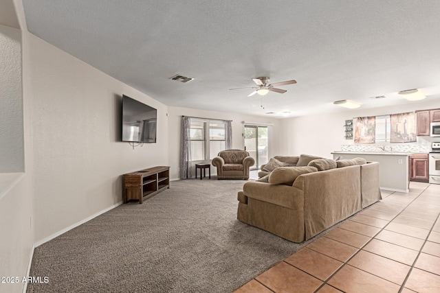 681 W Racine Loop, Casa Grande, AZ 85122 - living area with a ceiling fan, a textured ceiling, light tile patterned floors, and baseboards