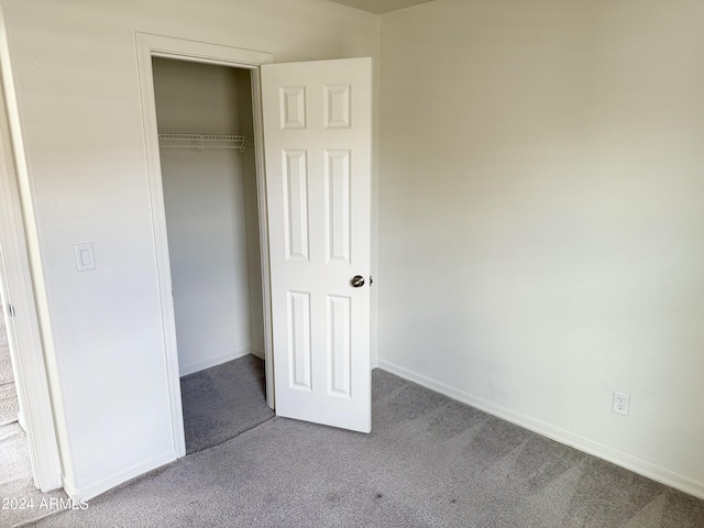 unfurnished bedroom with a closet and carpet flooring