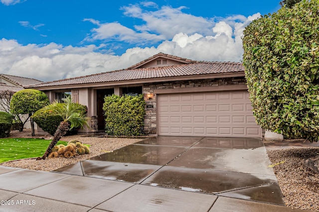 single story home with a garage, concrete driveway, stone siding, a tiled roof, and stucco siding