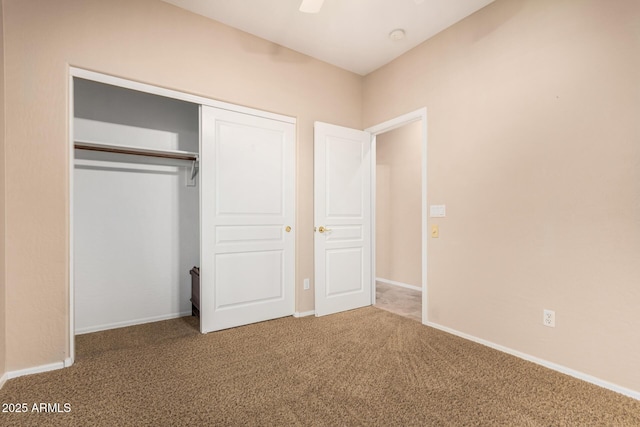 unfurnished bedroom featuring carpet floors, a closet, and baseboards