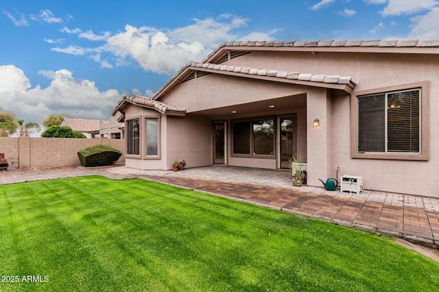 back of property with a patio area, a yard, fence, and stucco siding