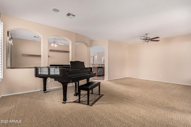 sitting room with carpet flooring, ceiling fan, visible vents, and baseboards