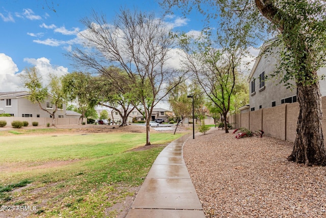 surrounding community with a residential view, fence, and a lawn