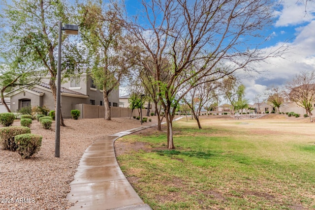 view of home's community with a residential view, a lawn, and fence