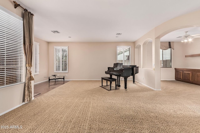 living area with arched walkways, visible vents, and baseboards