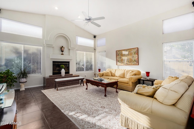 tiled living room with high vaulted ceiling, ceiling fan, and a fireplace