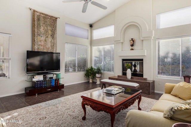 living room with high vaulted ceiling, a healthy amount of sunlight, ceiling fan, and dark tile patterned flooring