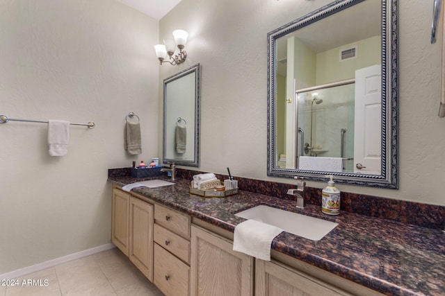 bathroom featuring tile patterned flooring, vanity, and a shower with shower door