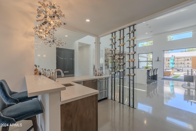 kitchen featuring concrete flooring, sink, a breakfast bar, and kitchen peninsula