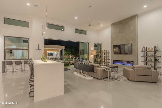 living room featuring a towering ceiling and a large fireplace