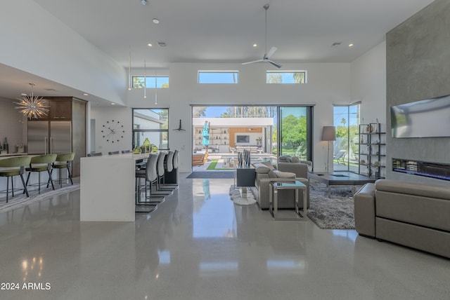 living room with a towering ceiling and ceiling fan