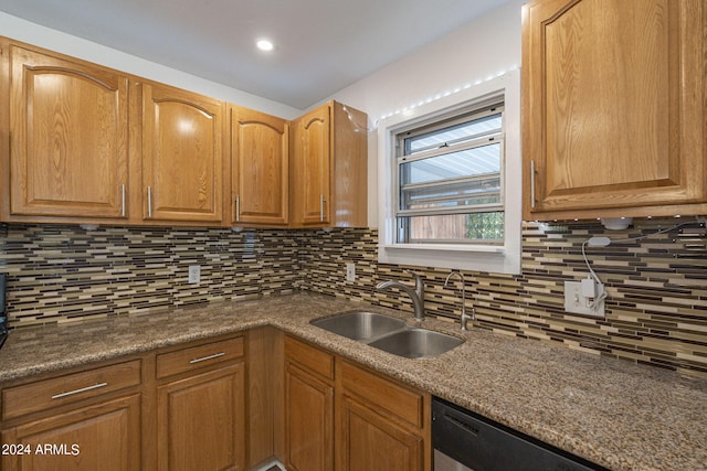 kitchen with stainless steel dishwasher, tasteful backsplash, brown cabinetry, and a sink