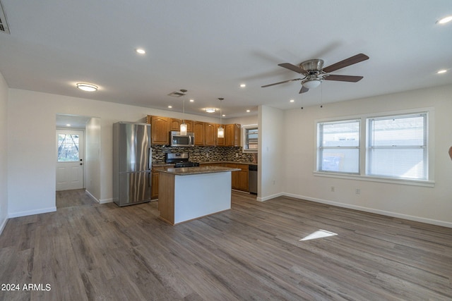 kitchen with a kitchen island, hardwood / wood-style flooring, stainless steel appliances, and a wealth of natural light