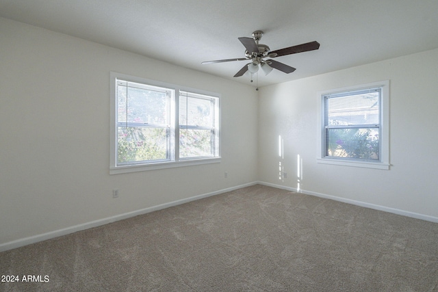 spare room featuring light carpet, baseboards, and a ceiling fan