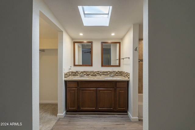 bathroom with double vanity, decorative backsplash, a sink, and washtub / shower combination