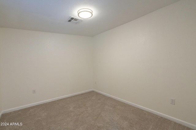 carpeted empty room featuring visible vents and baseboards