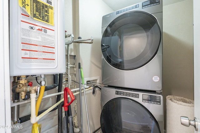 washroom featuring laundry area, stacked washing maching and dryer, and water heater
