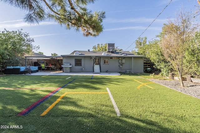rear view of house with central AC unit, a yard, outdoor lounge area, fence, and a patio