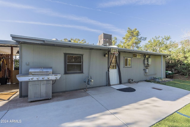 back of property with an outdoor living space with a fire pit, a lawn, a chimney, fence, and a patio