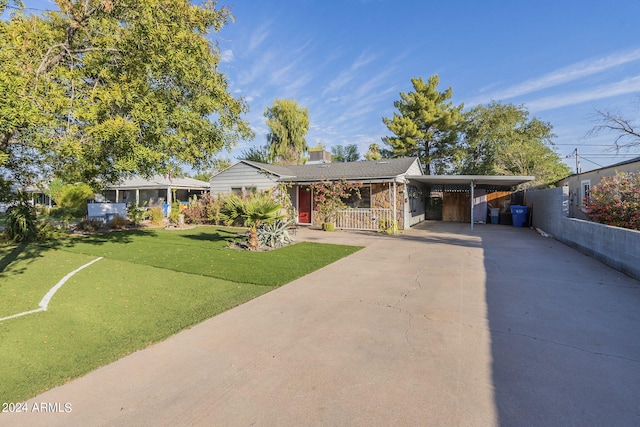 single story home featuring a carport, driveway, and a front lawn