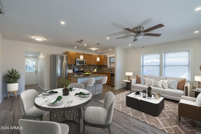 dining area with a healthy amount of sunlight, ceiling fan, and dark wood-type flooring