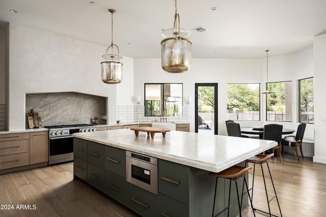 kitchen with tasteful backsplash, dark hardwood / wood-style floors, stainless steel appliances, and a kitchen island