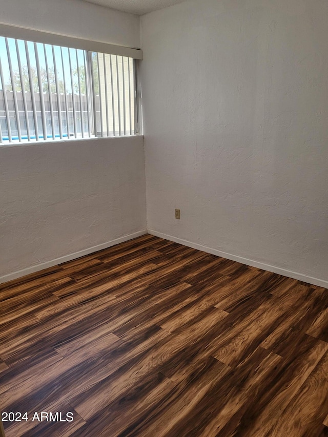 empty room with dark hardwood / wood-style flooring