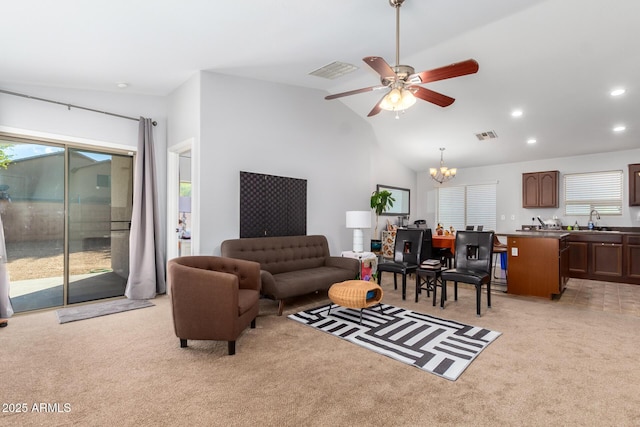 carpeted living room with sink, vaulted ceiling, and ceiling fan with notable chandelier