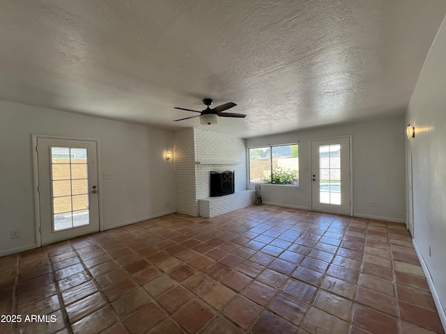 1618 W Vernon Ave, Phoenix, AZ 85007 - unfurnished living room with ceiling fan, a brick fireplace, baseboards, a textured ceiling, and tile patterned floors