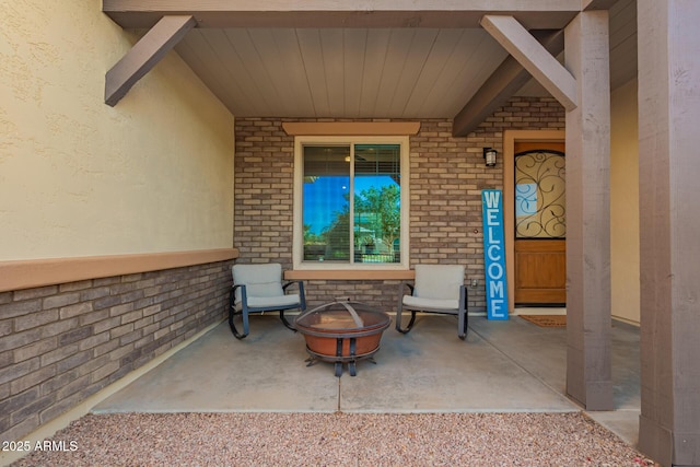 view of exterior entry featuring a patio area and brick siding