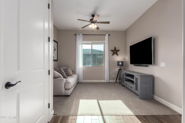 living room with baseboards, a ceiling fan, and wood finished floors