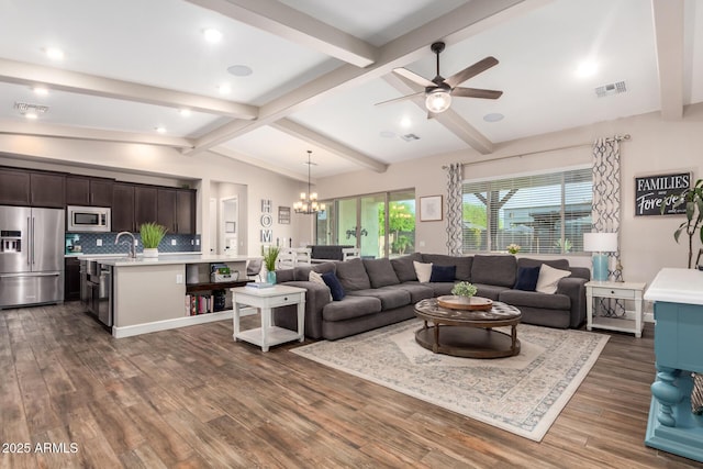 living area featuring visible vents, lofted ceiling with beams, ceiling fan with notable chandelier, and dark wood finished floors