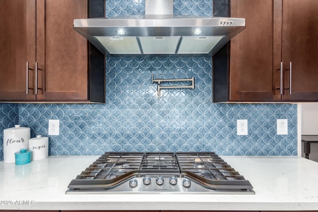 kitchen with backsplash, stainless steel gas stovetop, and wall chimney exhaust hood