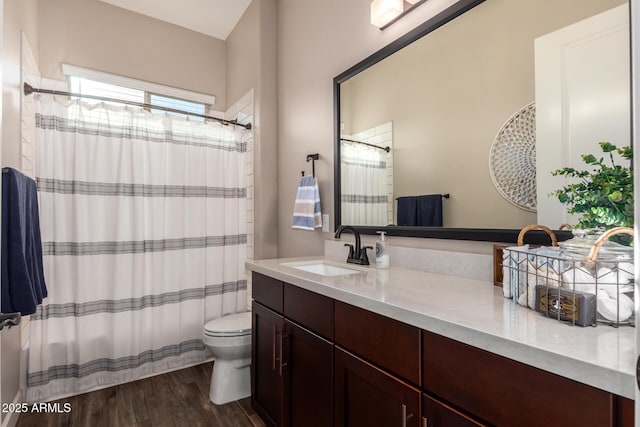 full bath featuring toilet, wood finished floors, vanity, and a shower with curtain