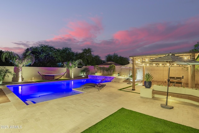 pool at dusk with a patio area, a fenced backyard, a fenced in pool, and area for grilling