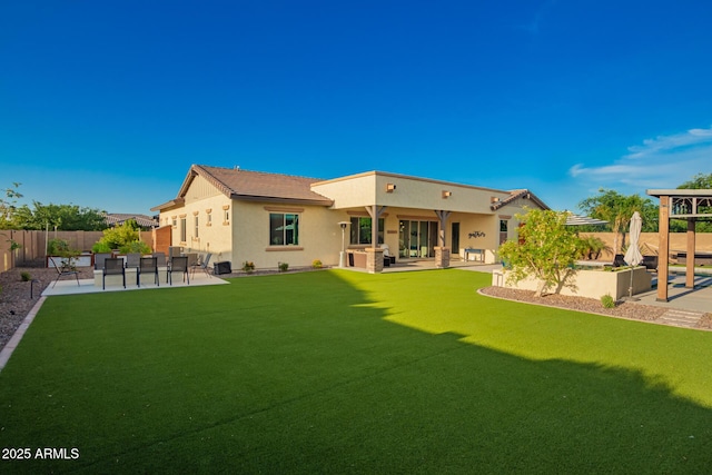 back of property featuring a patio area, a fenced backyard, a yard, and stucco siding