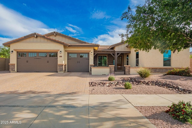 view of front facade with a garage, stucco siding, a tiled roof, and decorative driveway
