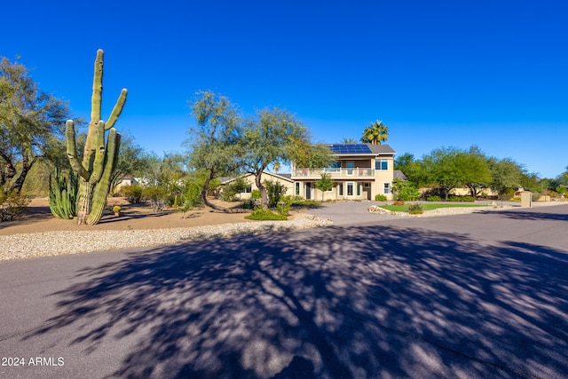 view of front of property featuring solar panels and a balcony