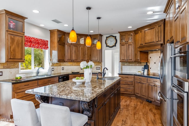 kitchen with dark stone counters, a center island, pendant lighting, and sink