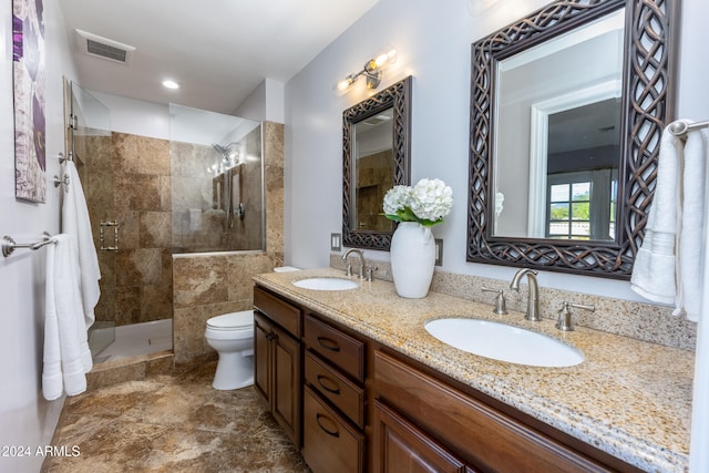 bathroom featuring toilet, a tile shower, and vanity