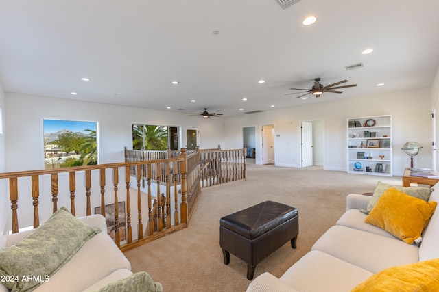 carpeted living room with built in shelves and ceiling fan