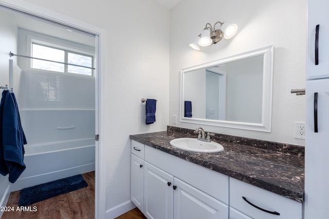 bathroom featuring washtub / shower combination, vanity, and hardwood / wood-style flooring