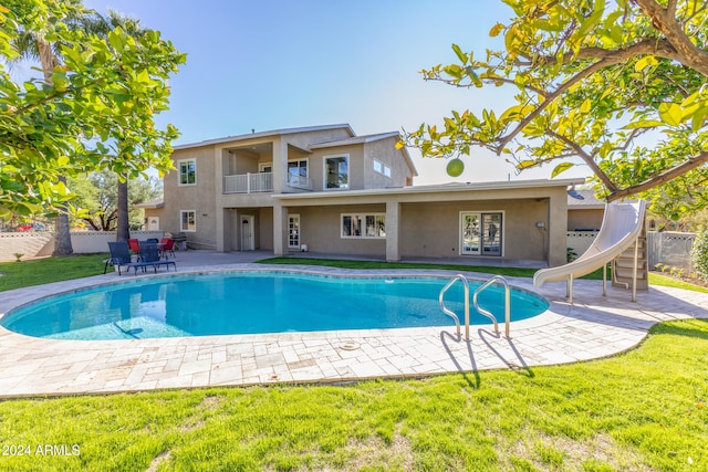 view of pool with a yard, a water slide, and a patio