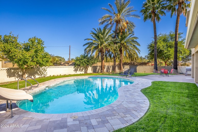 view of pool with a patio area, a yard, and a water slide