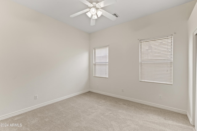 carpeted spare room featuring ceiling fan