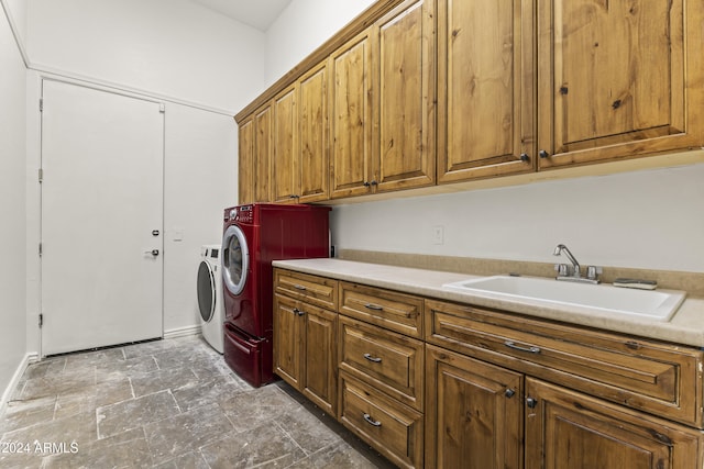 laundry area with separate washer and dryer, sink, and cabinets