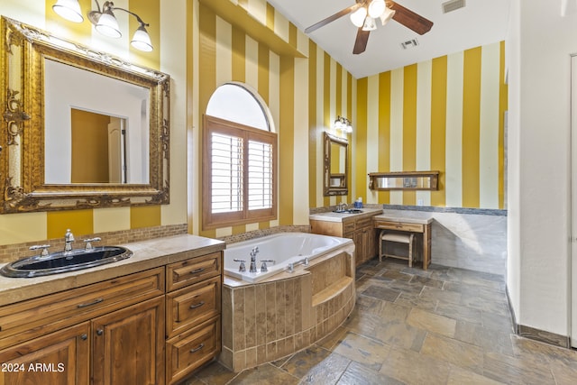 bathroom featuring vanity, ceiling fan, and tiled tub