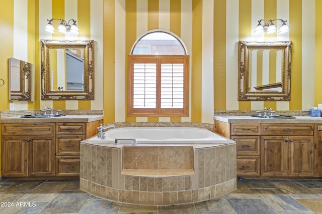 bathroom featuring a relaxing tiled tub and vanity