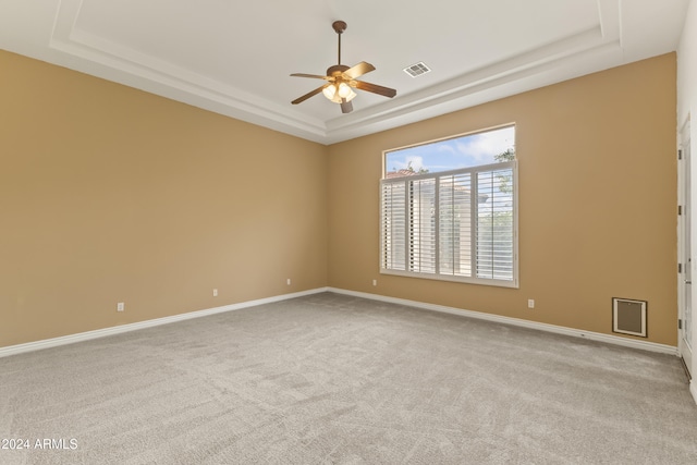 carpeted empty room featuring ceiling fan and a tray ceiling