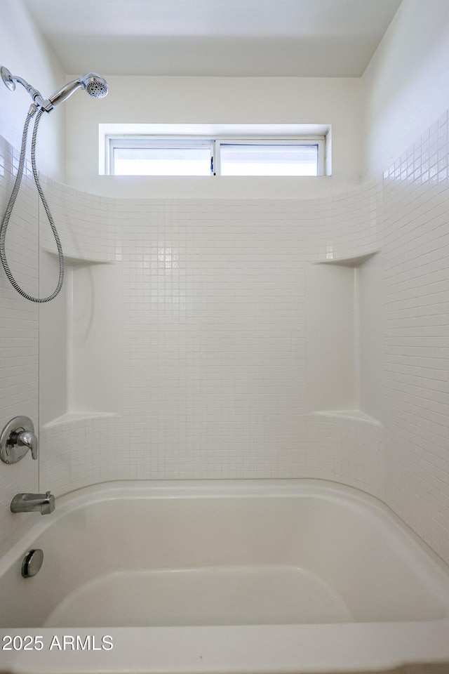 bathroom featuring plenty of natural light and bathing tub / shower combination